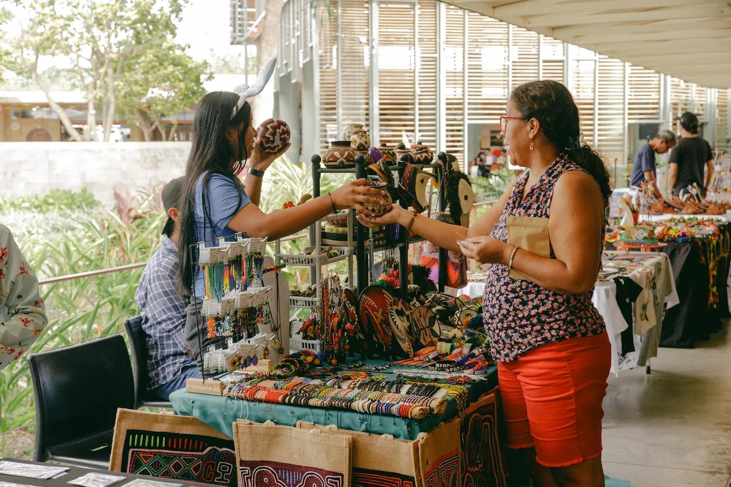 Mujer atiende en su puesto a una compradora en el bazar de Ciudad del Saber