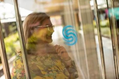 Mujer se refleja en una puerta de vidrio de Ciudad del Saber