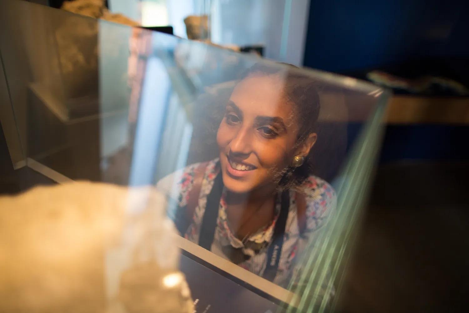 Reflejo de una mujer sonriente en una ventana de vidrio