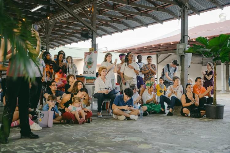 Perosnas reunidas escuchan atentamente iniciativas artísticas