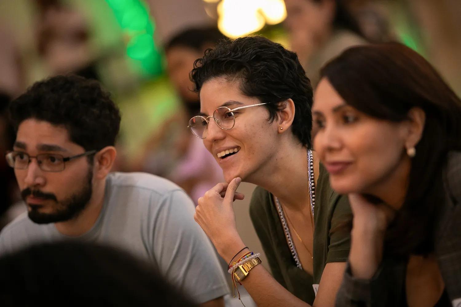Mujer sonriente acompañada de otros compañeros de trabajo