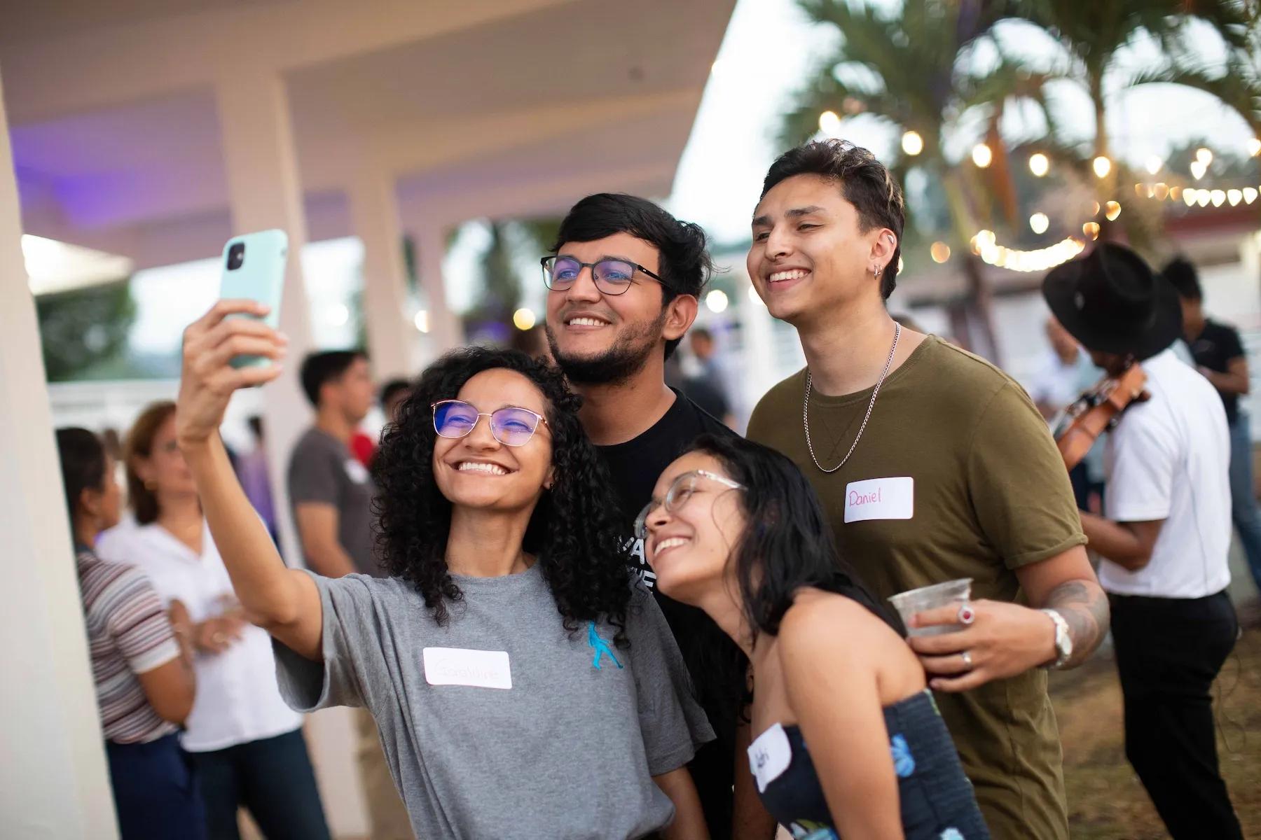 Personas posando y sonriendo para un selfie durante un evento en Ciudad del Saber.