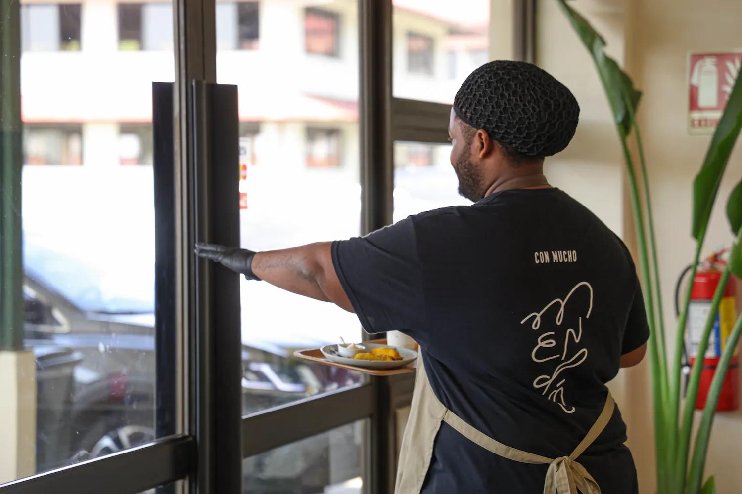 Mesero lleva un pedido a una mesa