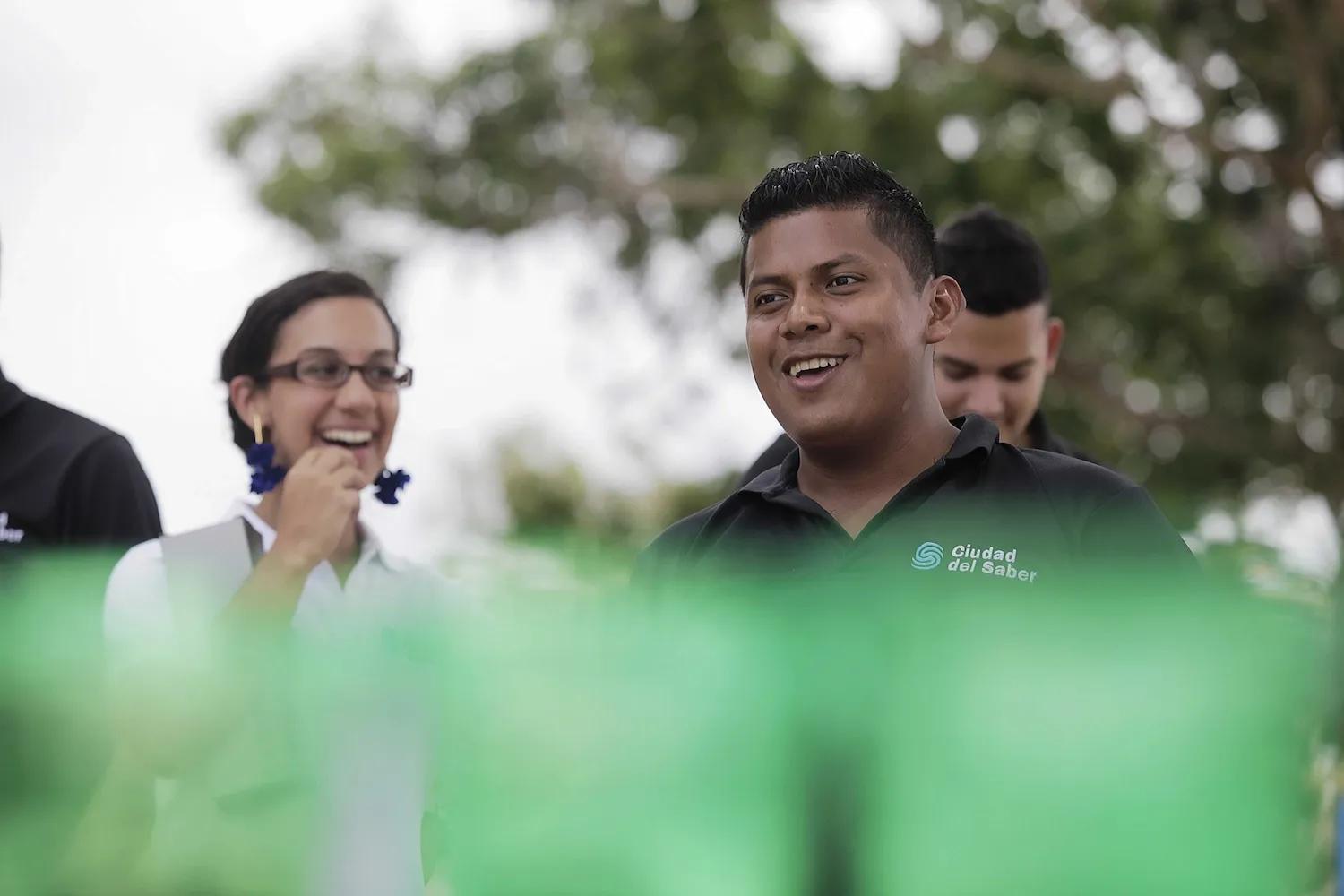 Hombre y mujer empleados de Ciudad del Saber sonrientes disfrutan una actividad