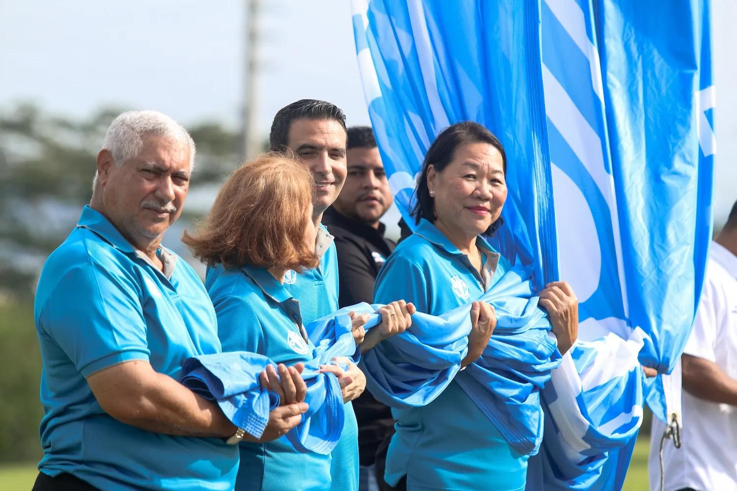 Personas sostienen la bandera de Ciudad del Saber mientras es izada