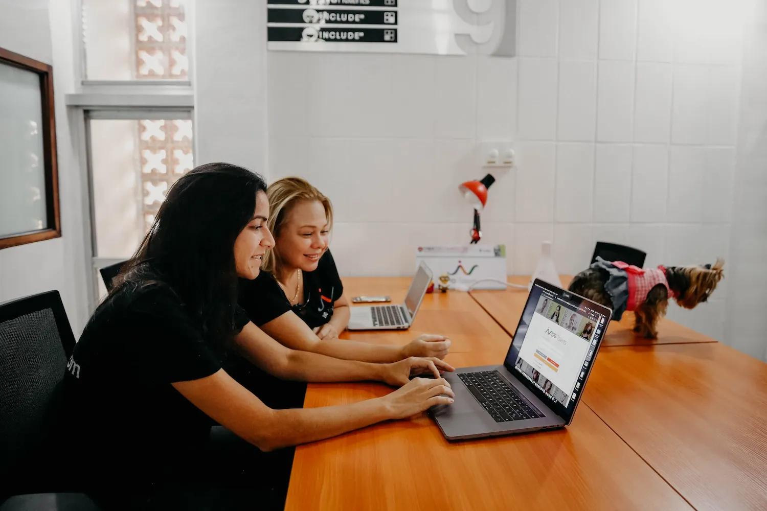 Mujeres interactúan en una oficina con su computador