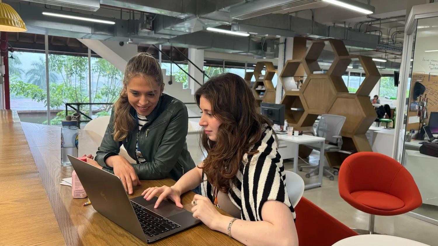 Mujeres interactúan en un computador en la oficina de Ciudad del Saber