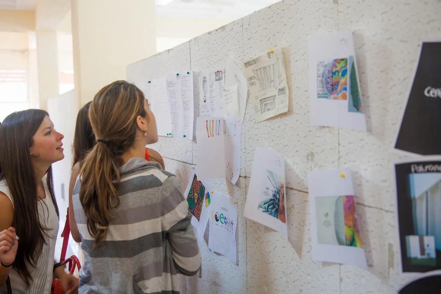 Mujeres leen atentamente información de una cartelera informativa